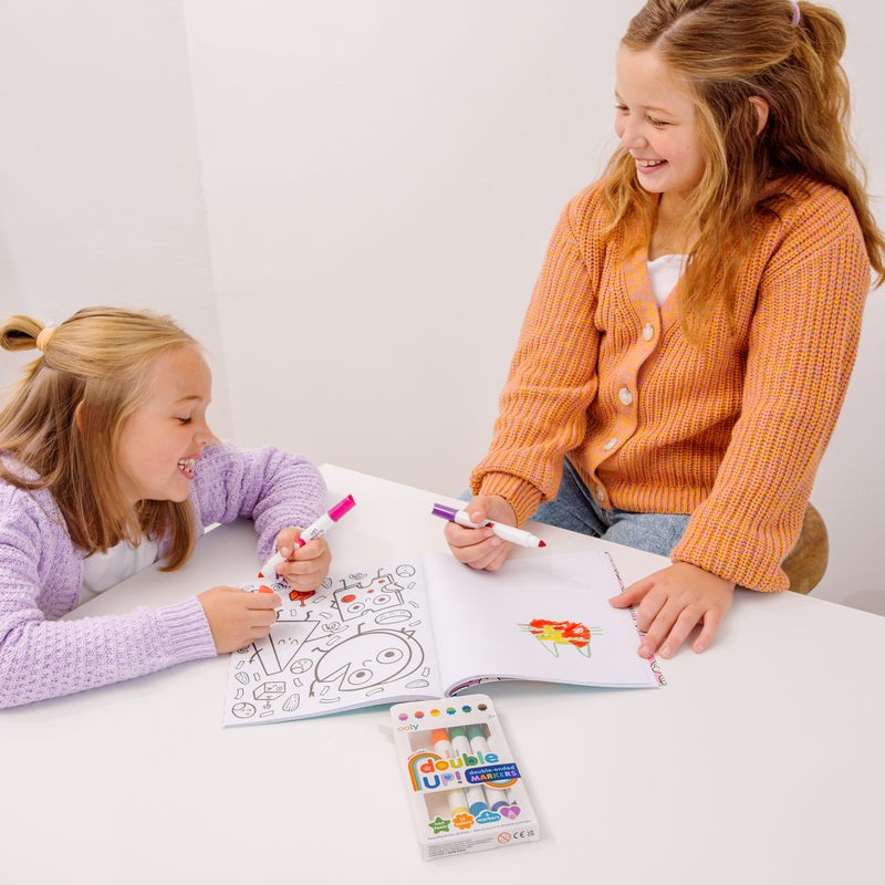 Two girls coloring with OOLY Double Up! Double Ended Markers on white table