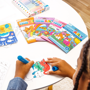 Child coloring OOLY hidden pattern coloring books with markers on white table