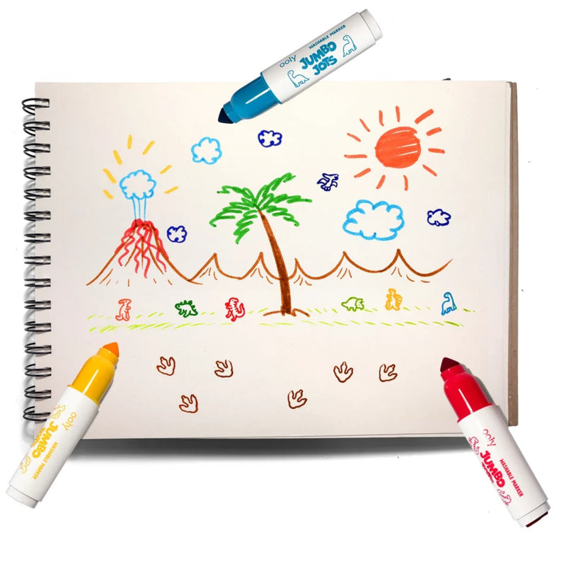 A spiral-bound sketchbook with a colorful childlike drawing of a volcano, palm tree, sun, clouds, and small figures, surrounded by three markers on a white background.