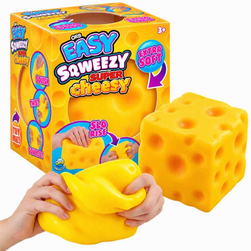 A yellow cheese-shaped squishy toy shown with a person's hands squeezing it, alongside its bright yellow retail box. The box features colorful text including 'EASY SWEEZY SUPER cheesy' and 'EXTRA SOFT'.