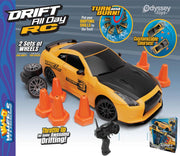 Odyssey Toys Drift All Day RC remote control car toy set, featuring a yellow and black sports car, orange traffic cones, a black remote control transmitter, spare wheels, and the product packaging box on a blue and white graphic background.