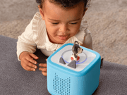 Young child playing with blue TonieBox featuring Playtime Puppy character on top