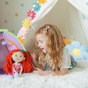 Young girl playing with Groovy Girls Poppy red-haired plush doll in decorated playroom tent.