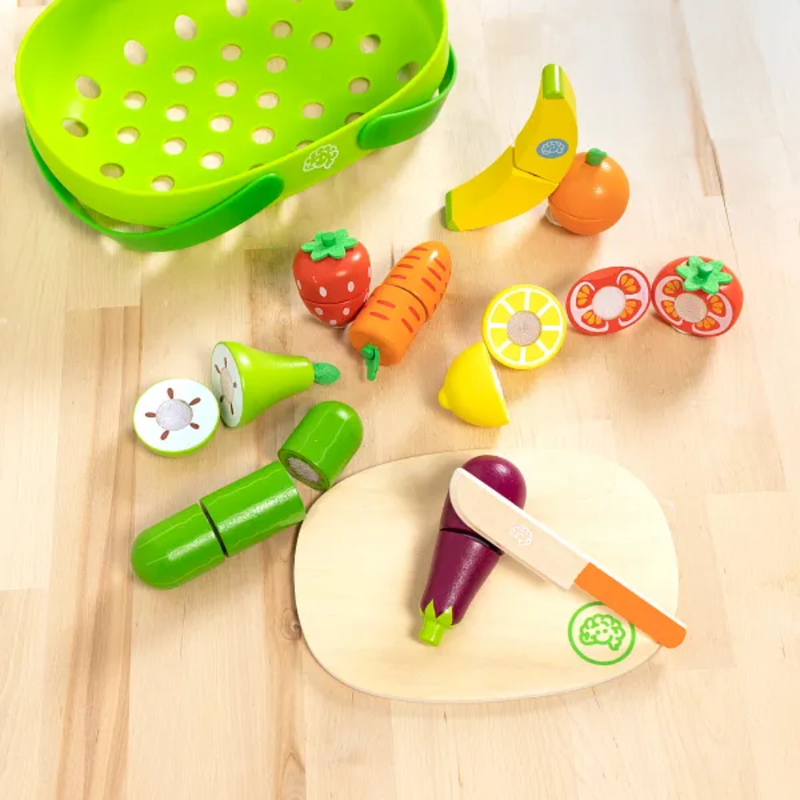 Colorful toy kitchen set with fruits, vegetables, and utensils on a wooden surface