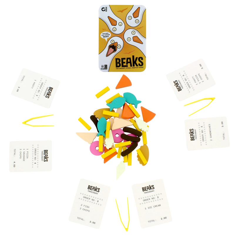 The Beaks card game set arranged on a white background, featuring a yellow tin with the Beaks logo, several cream-colored play money cards, and a central pile of colorful food-shaped tokens.