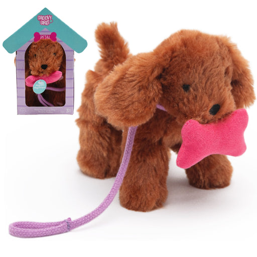 A brown plush dog toy holding a pink bone-shaped toy in its mouth, with a purple leash attached. A small inset at the upper left shows the toy inside a doghouse-shaped packaging display labeled 'Buddy's Pet Shop'.