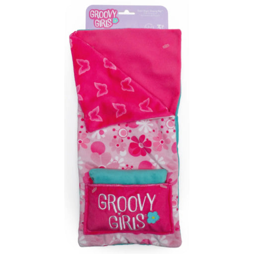 A packaged pink plush blanket or pillow set with a floral pattern, a folded pink section with heart motifs, and a front pocket printed with 'GROOVY GIRLS' on a white background.