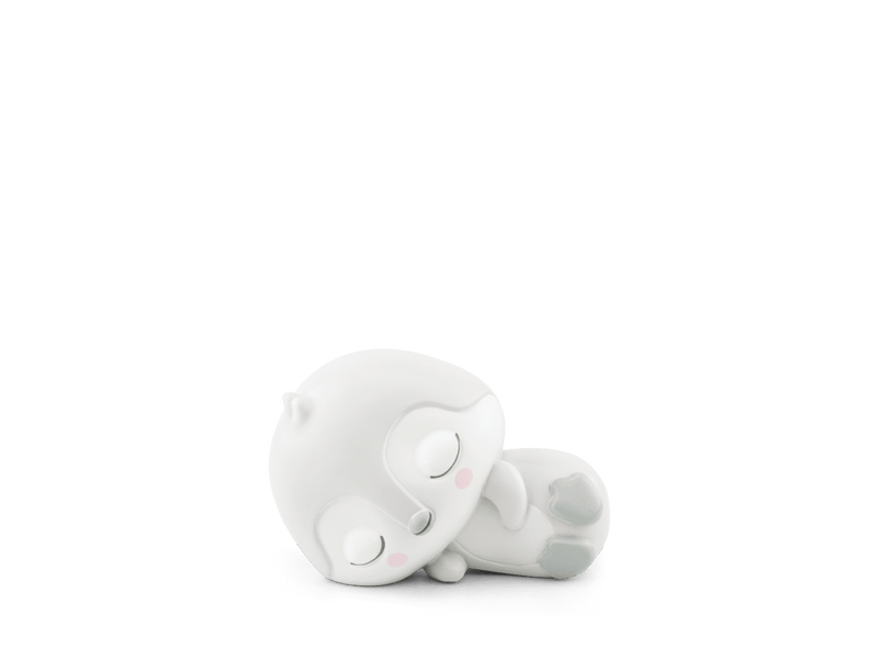 White sleeping penguin Tonie figure lying on side against green background