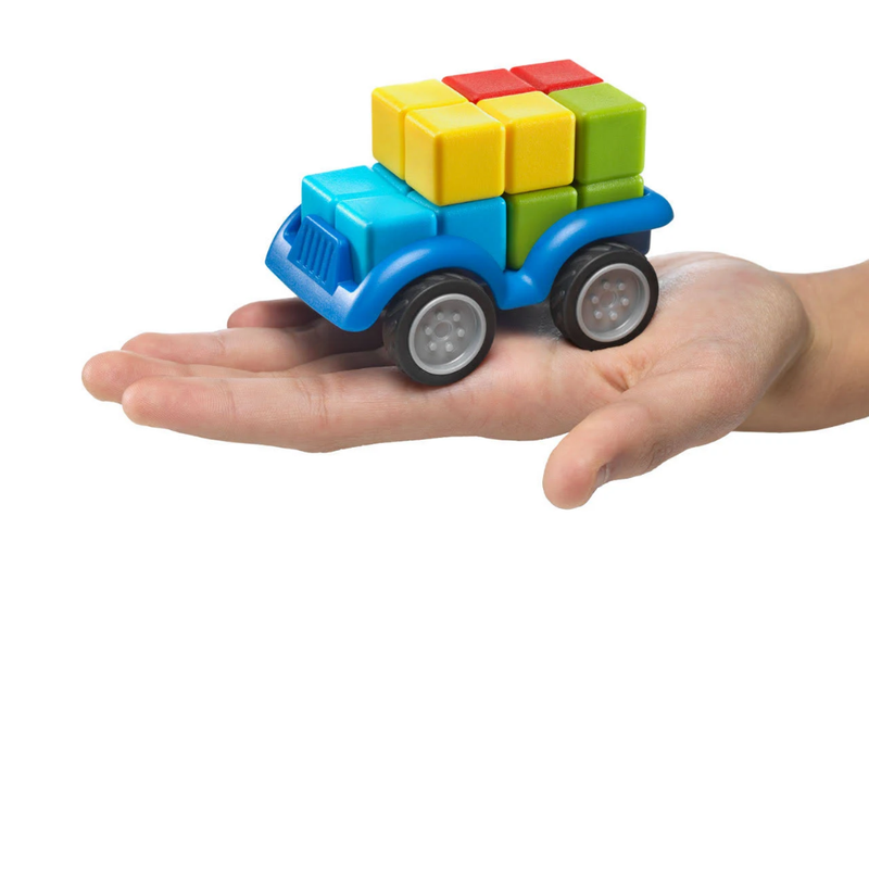 Colorful toy truck made of interlocking blocks held in a hand on a white background