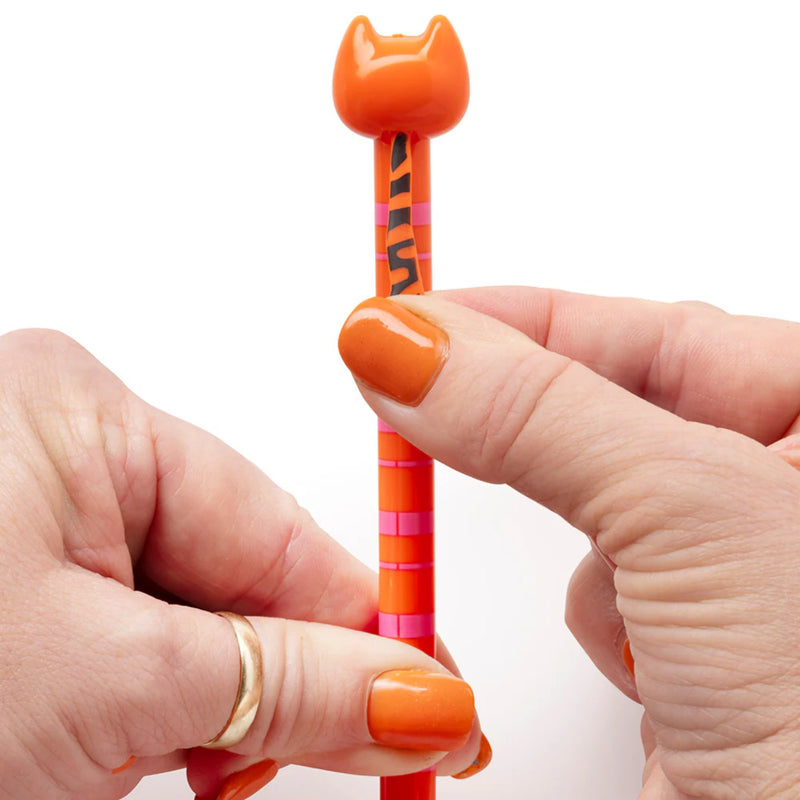 A close-up of hands holding an orange cat-shaped novelty pencil against a plain white background.