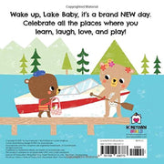 Back cover of a children's board book titled 'Wake up, Lake Baby, it's a brand NEW day.' The cover features a playful illustration of two cartoon bears in a red and white canoe on a wooden dock, with mountains and trees in the background.
