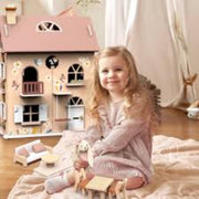 Young girl playing with a wooden dollhouse and toys in a cozy room.