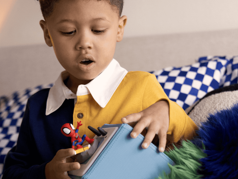 Child playing with Tonie Spiderman figure on audio device in lifestyle setting