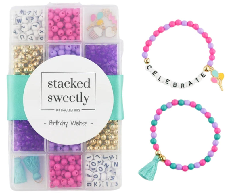 A DIY bracelet kit in a clear plastic organizer box with a turquoise ribbon, shown alongside two finished beaded bracelets: one with black letter beads spelling CELEBRATE and one with a turquoise tassel charm. The kit contains pink, purple, teal, gold, and white beads.