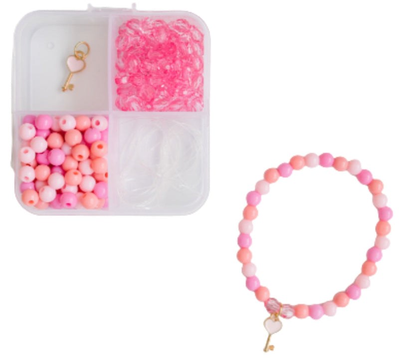 Pink beaded bracelet kit with a compartment organizer containing pink beads, a key charm, and a finished pink beaded bracelet with a key charm on a white background.
