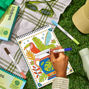 Hand coloring FlowArt Jungle Oasis sketchbook with tropical bird and plants design