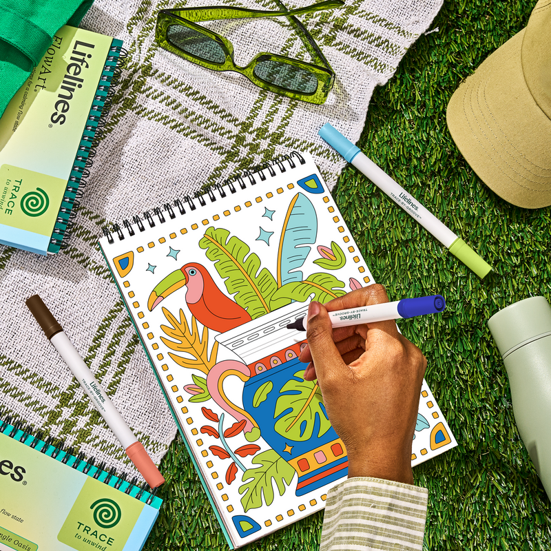 Hand coloring FlowArt Jungle Oasis sketchbook with tropical bird and plants design