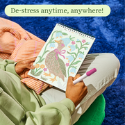 Person coloring woodland bird design in FlowArt trace-by-line coloring book with marker