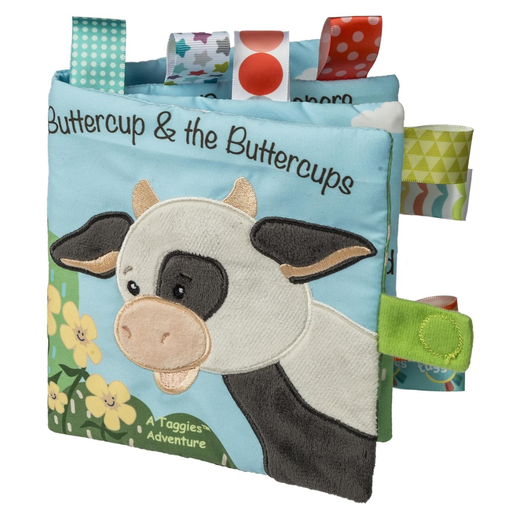 Taggies Children's soft book with a cow illustration and colorful tags on a white background.