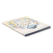 Cream colored book with decorative floral cover design featuring text