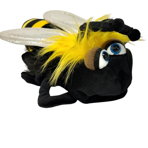 A plush toy bumblebee with a black body, yellow and black striped abdomen, fluffy yellow hair, clear wings, and large blue eyes, shown on a plain white background.