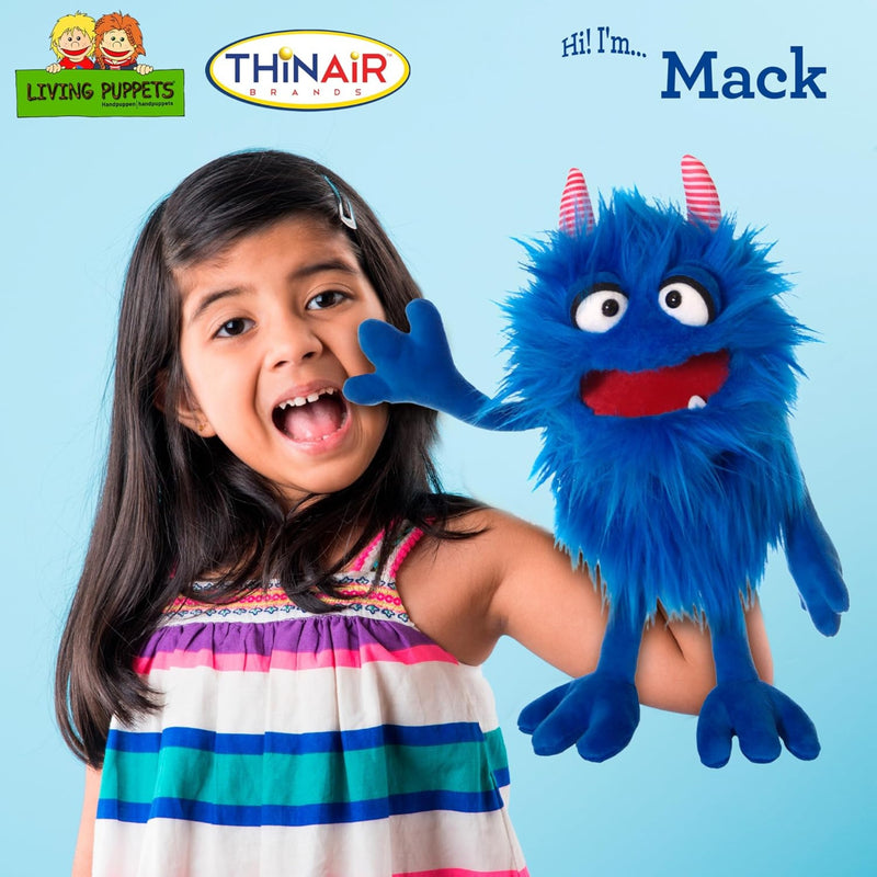 Young girl holding Mack a puppet from ThinAir.  The puppet is furry and bright blue with red striped horns and big eyes.  