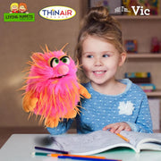 Child holding a colorful puppet named Vic from Living Puppets and ThinAir Puppetry logos.