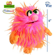 A pink and orange furry monster puppet by ThinAir Living Puppets toy labeled Vic.