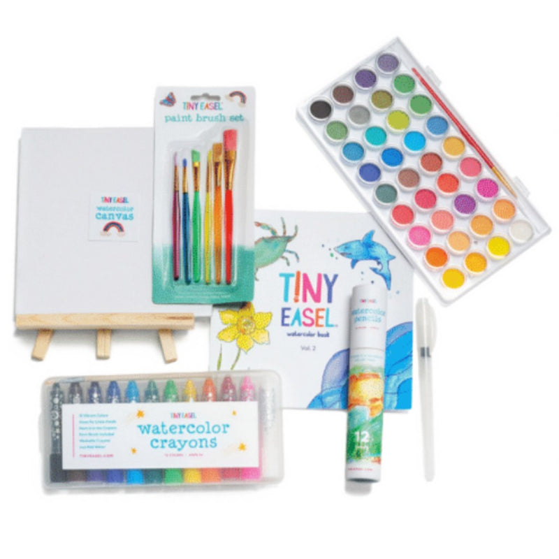 Art supplies including a paintbrush set, watercolor crayons, and a watercolor book on a white background.