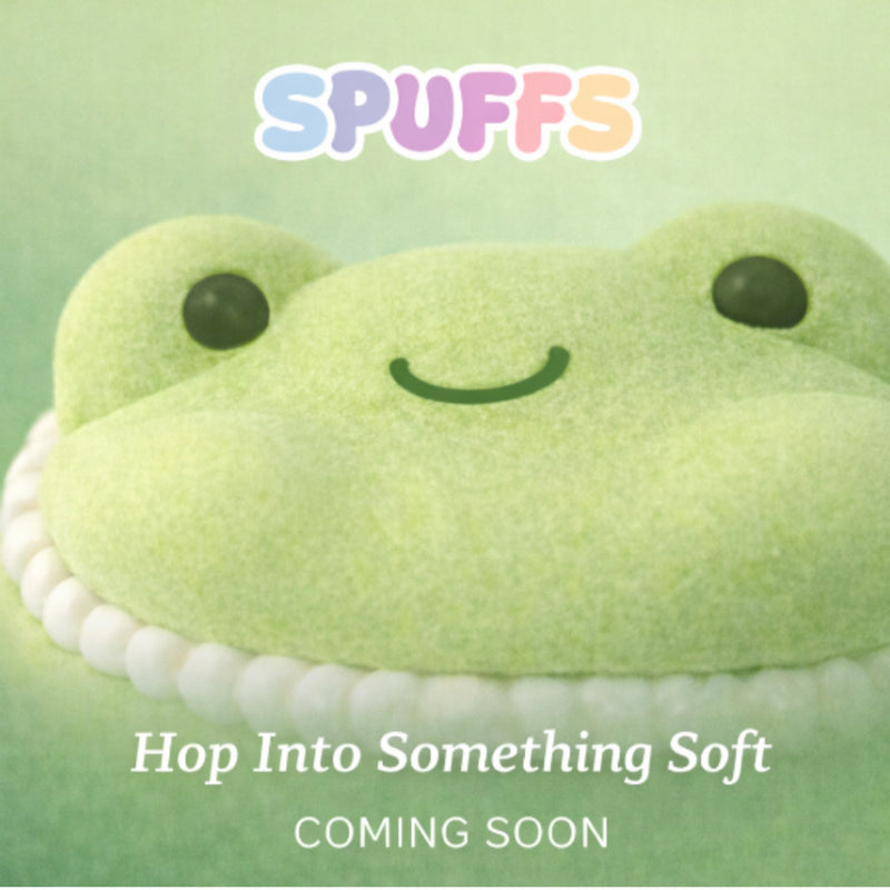 A green frog-shaped plush or soft toy with a smiling face and the word 'SPUFFS' above it, plus the text 'Hop Into Something Soft COMING SOON' on a pale green background.