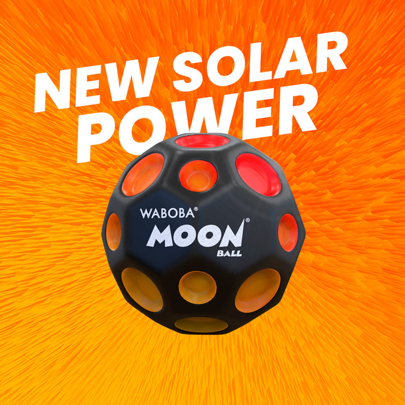 Waboba Moon Ball with crater-like holes on orange sunburst background