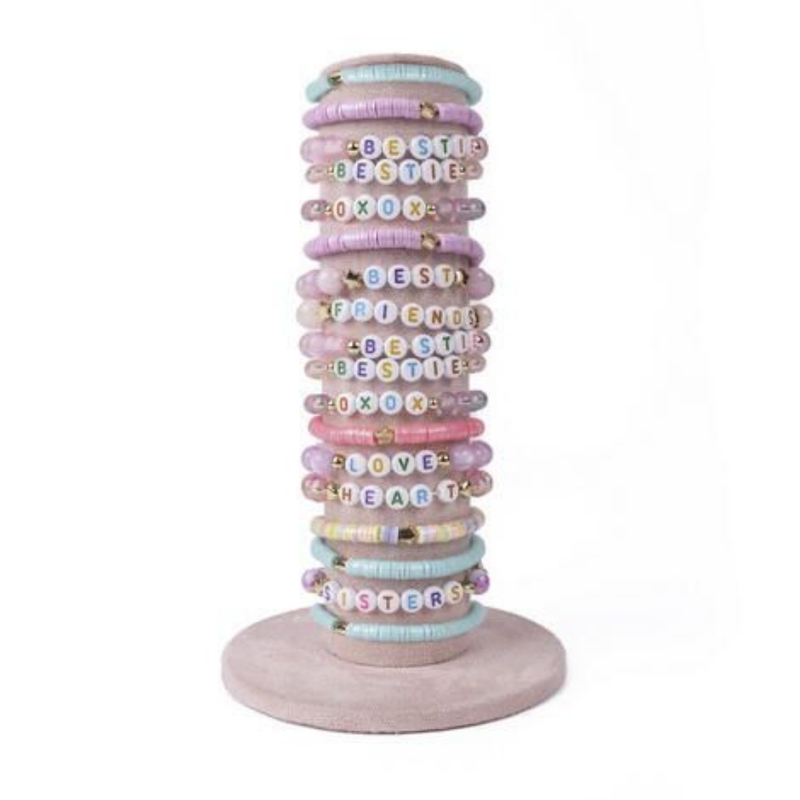 Stack of pastel colored beaded bracelets with letter beads on wooden stand