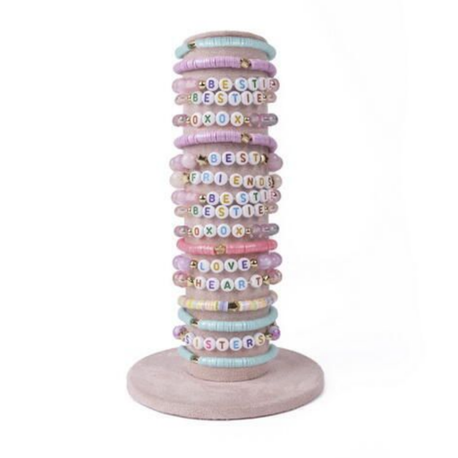 Stack of pastel colored beaded bracelets with letter beads on wooden stand