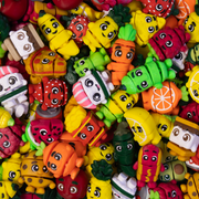 Assorted colorful 3D printed collectibles that look like popular food items -- french fries, carrots, hot dog, smores, strawberry and more.