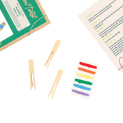 Colorful wooden sticks and rainbow-colored thread on a white background with instructions.