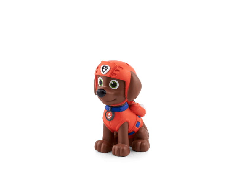 Tonie figurine of Zuma from Paw Patrol in red rescue uniform on plain background