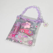 Clear purple handbag-style cosmetic kit with makeup items and flower decorations inside