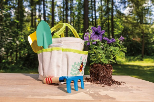 Kids garden hand tools set with tote bag, trowel, and fork displayed outdoors