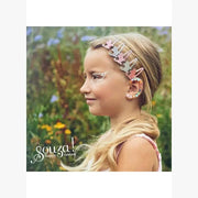 Young girl wearing multicolor earring stickers and hair clips in garden setting