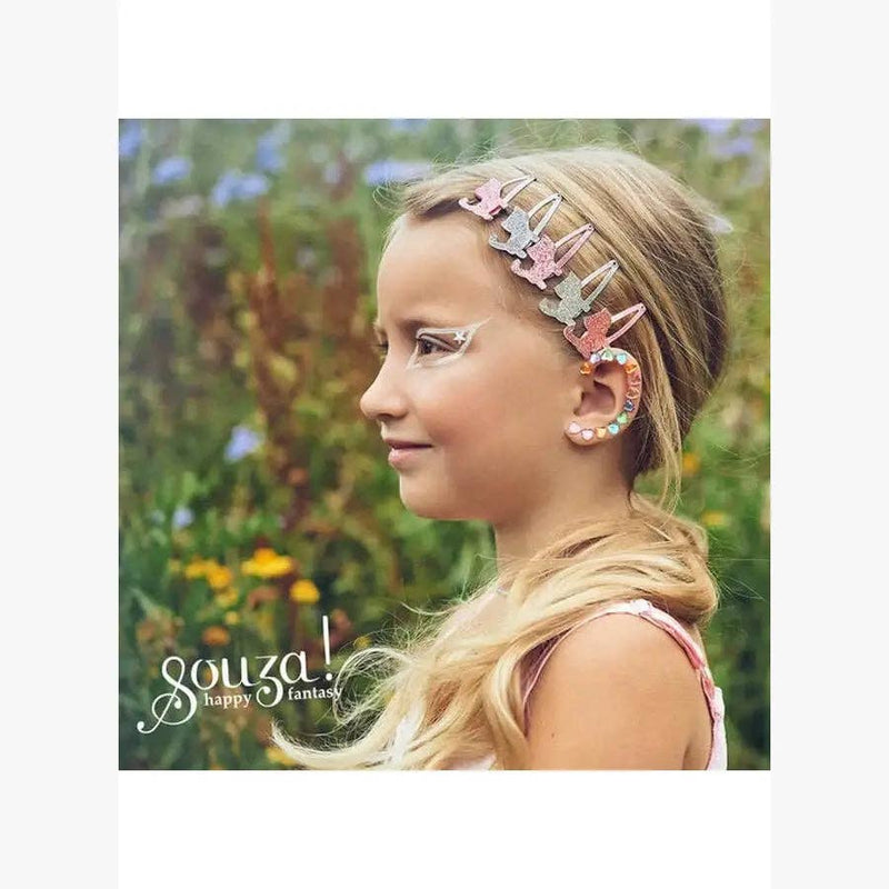 Young girl wearing multicolor earring stickers and hair clips in garden setting