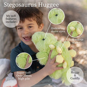 Child holding green Stegosaurus Hugee plush toy with feature callouts showing soft details