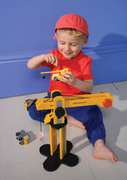 Child playing with yellow wooden construction crane toy on blue background