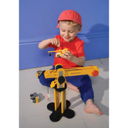 Child playing with yellow wooden construction crane toy on blue background