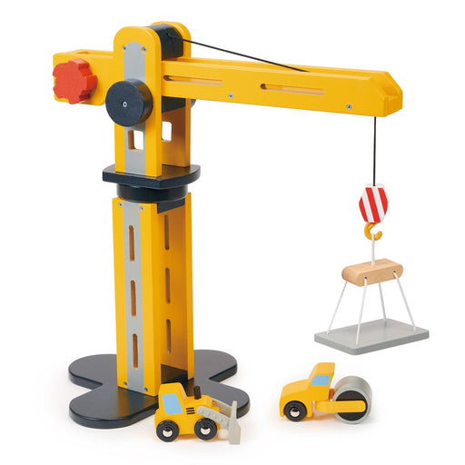 Yellow wooden toy construction crane with lifting hook and construction vehicles on white background