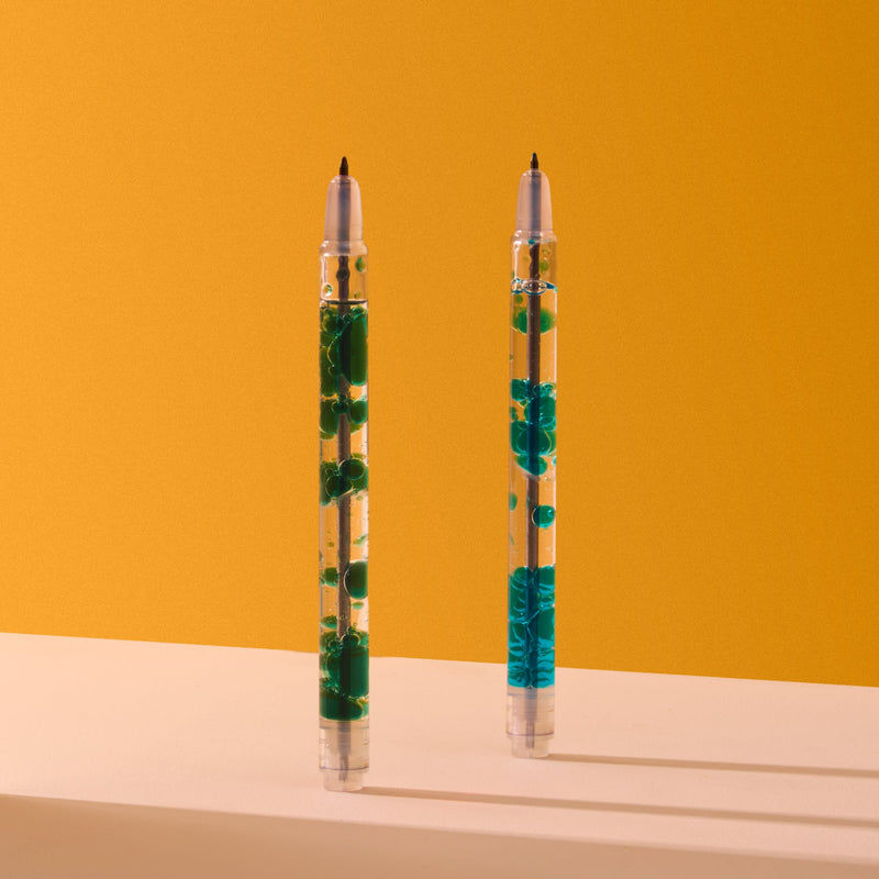 Two clear pens with blue and green liquid elements on orange background