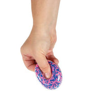 Hand holding colorful purple and blue speckled Atomic Air Ball stress toy