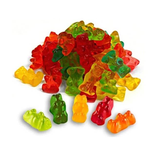 Colorful Haribo Gold Bears gummy candies scattered on white background showing various fruit flavors