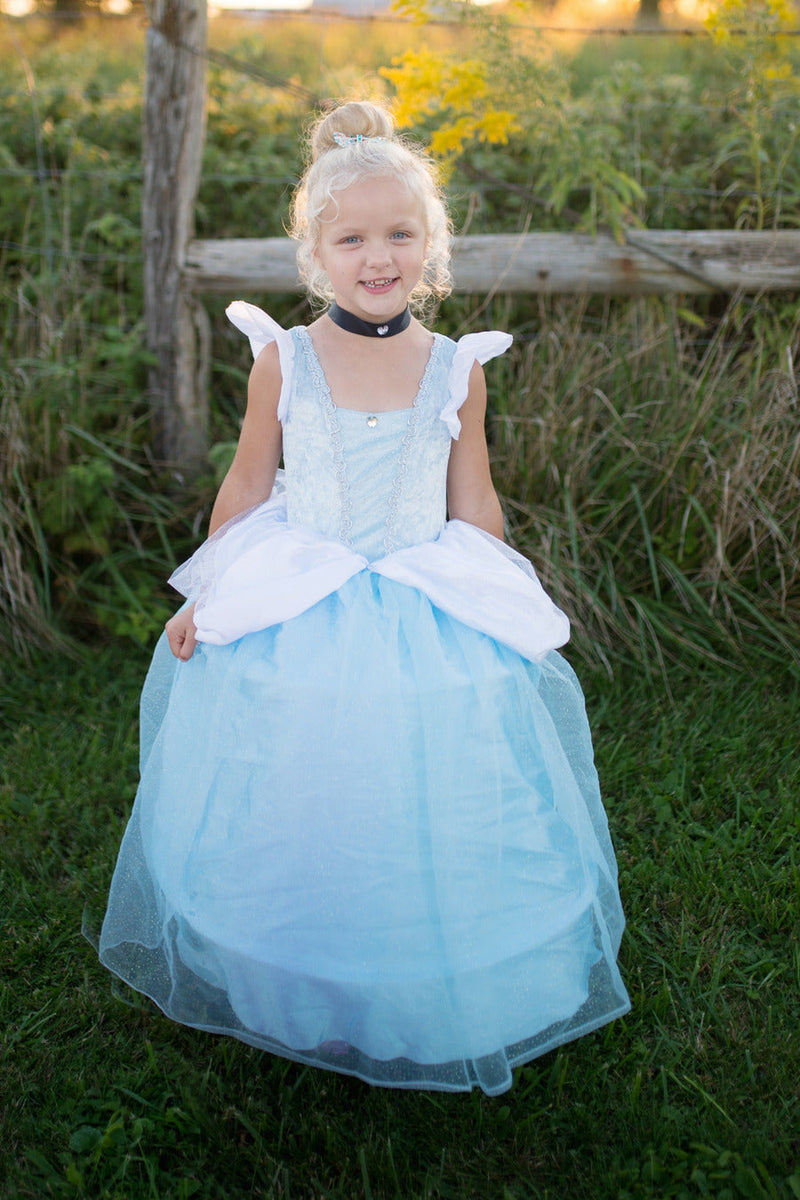 Young girl wearing light blue Cinderella princess gown costume in outdoor setting
