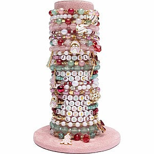 Stack of colorful beaded holiday bracelets displayed on pink cone stand
