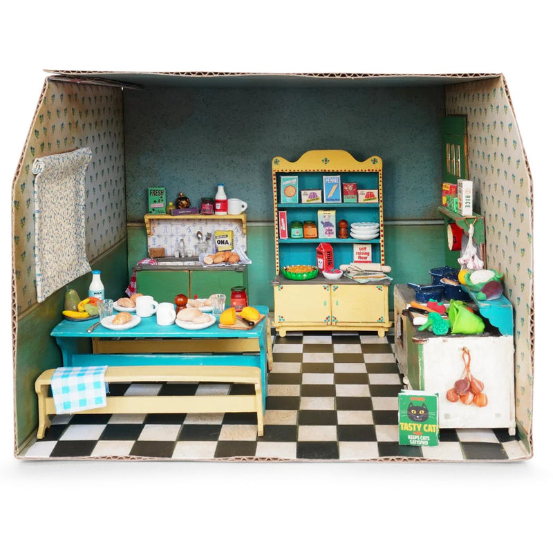 Cardboard dollhouse kitchen room with miniature furniture and accessories on checkered floor